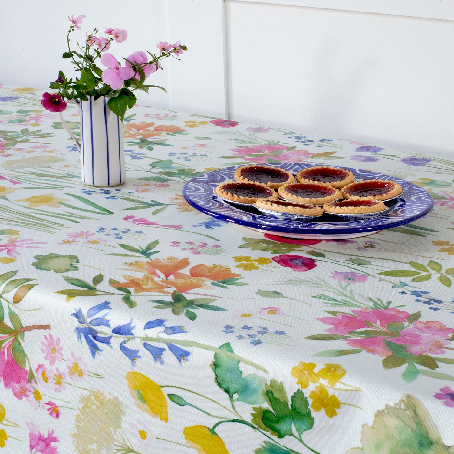 isolation garden oil cloth on table with flowers and cakes on top