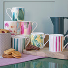 stacked bluebellgray mugs sitting next to biscuits on a counter